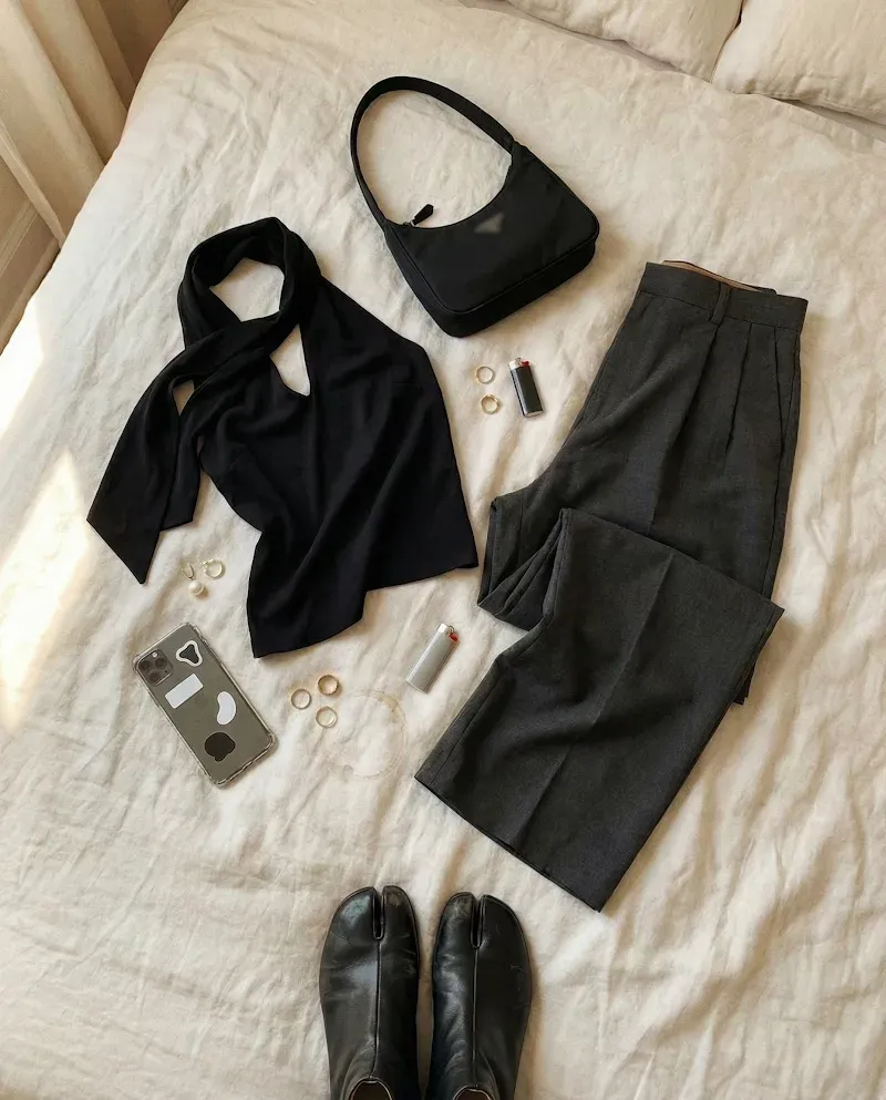 Flat-lay product input: a black fashion look arranged on a plain surface
